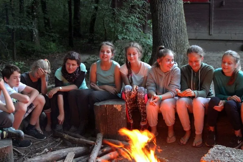 Jugendliche sitzen abends am Lagerfeuer