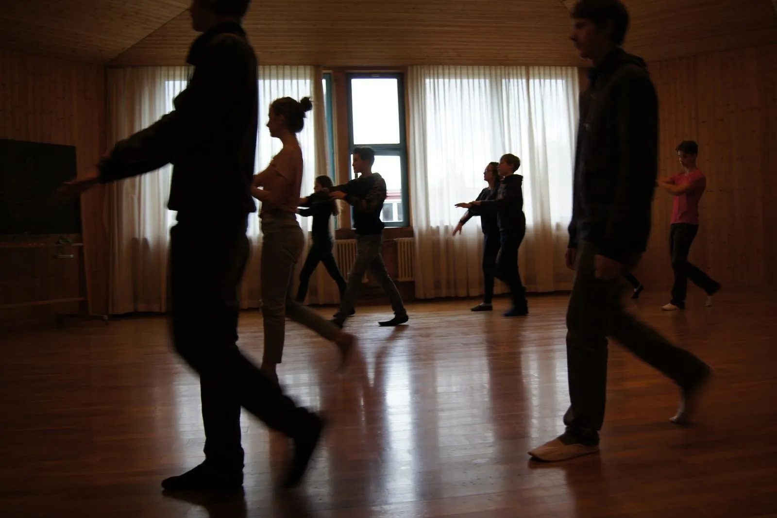Jugendliche der Oberstufe bewegen sich beim Eurythmieunterricht durch den Saal