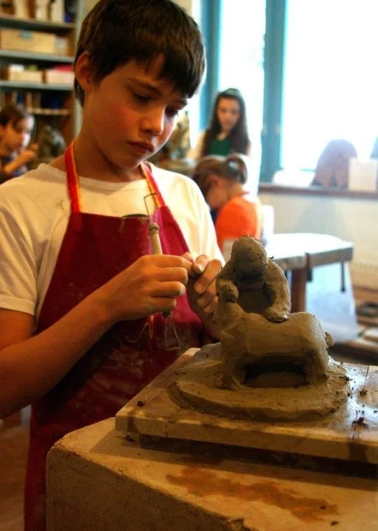 Ein Kind formt eine Figur aus Ton
